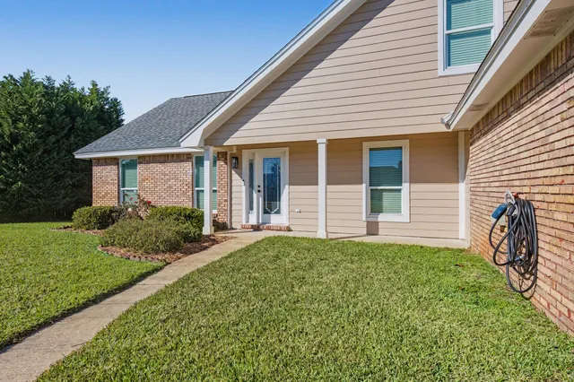 a kitchen with stainless steel appliances granite countertop a sink a stove and white cabinets