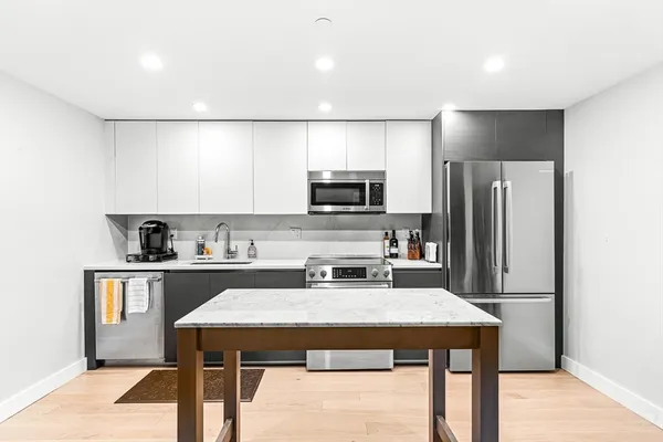 a kitchen with a sink a microwave a refrigerator and cabinets