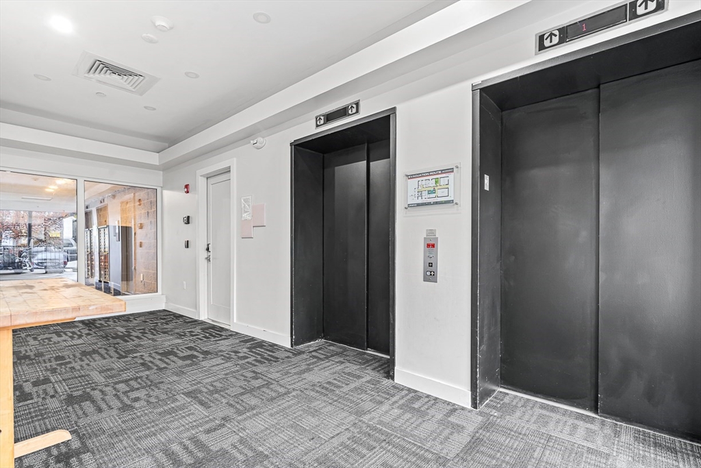 932 Broadway, Unit 208 Chelsea, MA 02150 - Photo 22 of 24 a view of a hallway with wooden floor and a bathroom