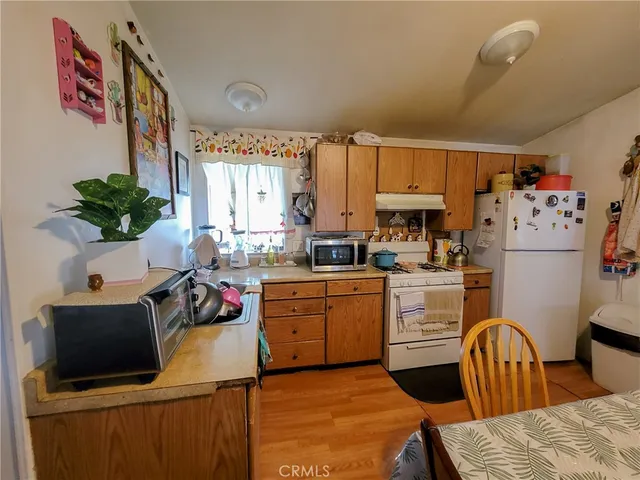 a kitchen with a refrigerator and a stove top oven