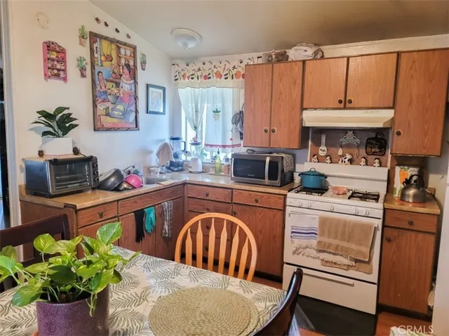 a kitchen with a table chairs stove and cabinets