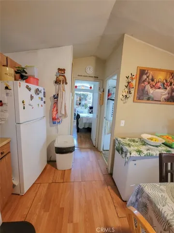 a kitchen with a refrigerator and wooden floor