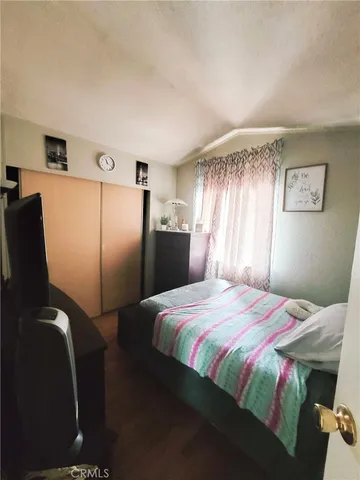 a bedroom with a bed and a refrigerator