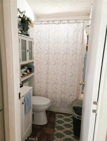 a bathroom with a toilet and a shower curtain