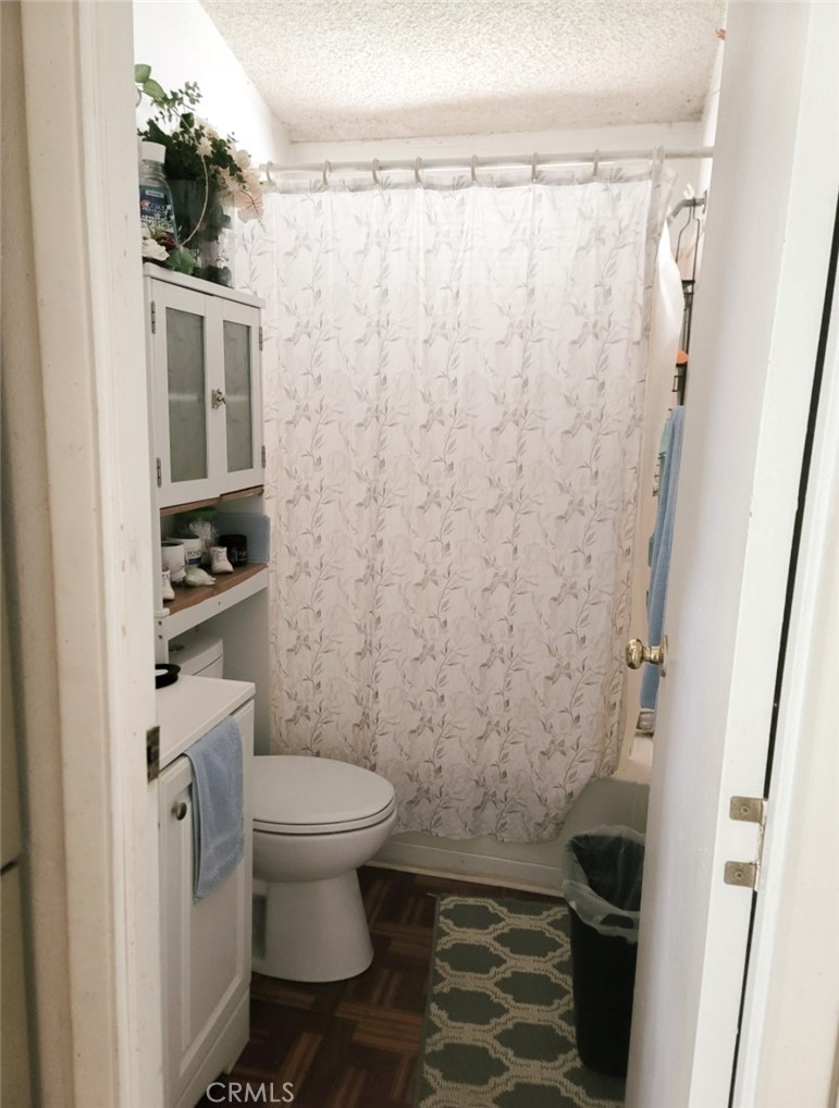 2500 North State Highway 59, Unit 278 Merced, CA 95348 - Photo 25 of 30 a bathroom with a toilet and a shower curtain
