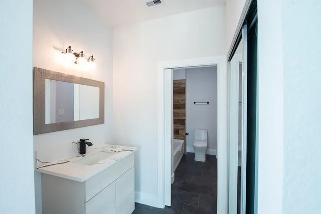 a view of empty room with windows and ceiling fan