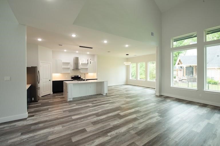 216 Monterrey Road West Montgomery, TX 77356 - Photo 6 of 26 a large kitchen with kitchen island a sink wooden floor and a large window
