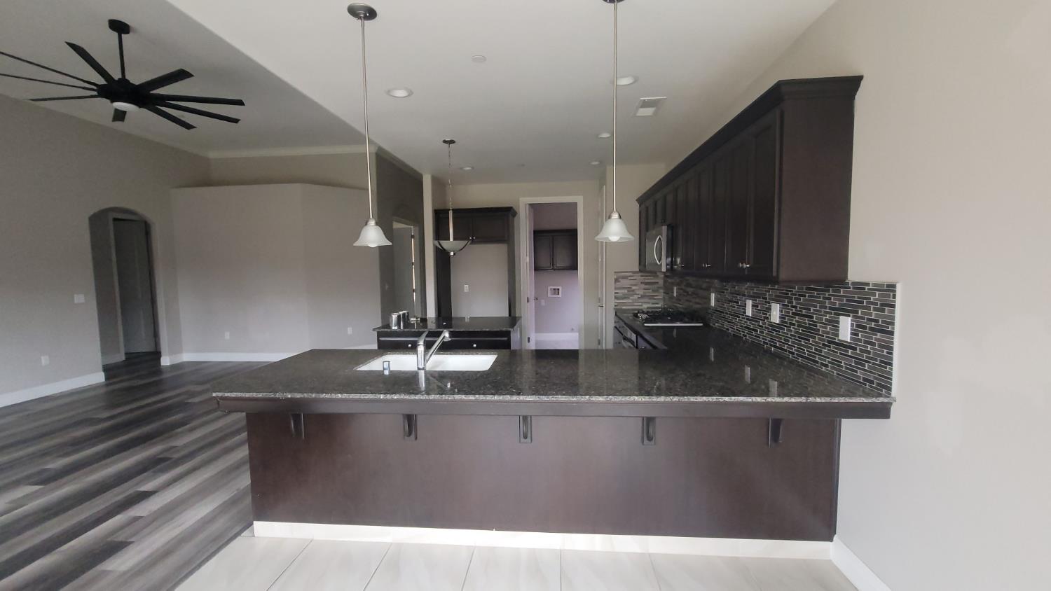 4349 Wickson Place Merced, CA 95348 - Photo 8 of 22 a kitchen with stainless steel appliances granite countertop a sink a stove and a microwave oven
