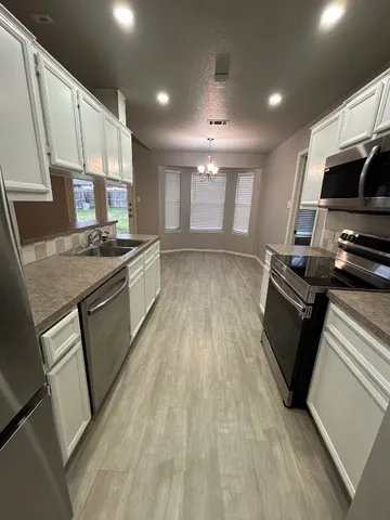 a kitchen with stainless steel appliances granite countertop a stove a sink and a refrigerator