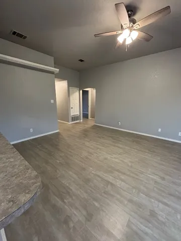 an empty room with fan and windows