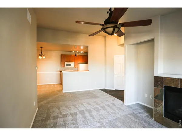 a view of an empty room and window and ceiling fan
