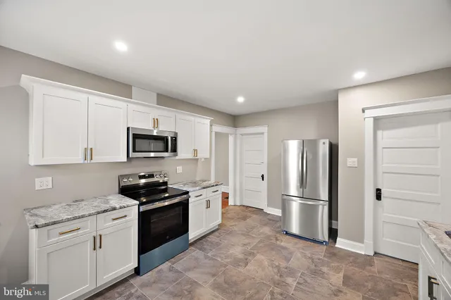 a kitchen with stainless steel appliances granite countertop a refrigerator sink and stove