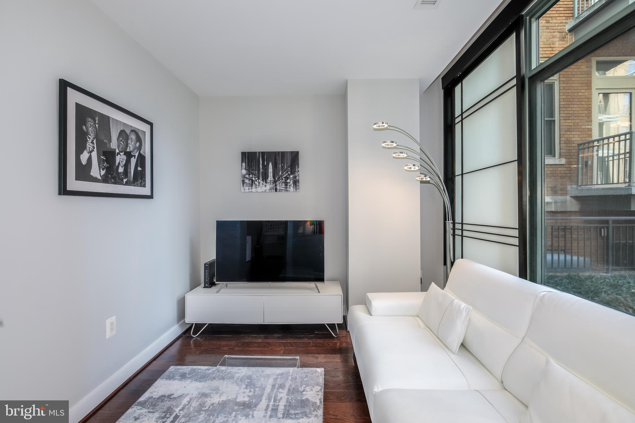2425 L Street Northwest, Unit 211 Washington, DC 20037 - Photo 13 of 43 a living room with furniture and a window