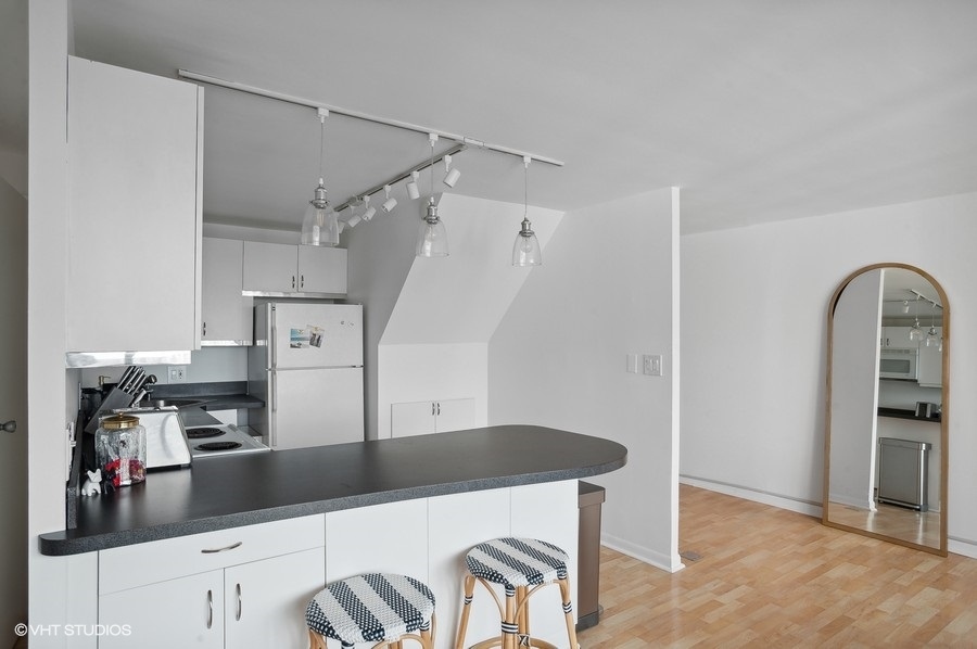 1221 North Dearborn Parkway, Unit PH10N Chicago, IL 60610 - Photo 9 of 23 a kitchen with stainless steel appliances granite countertop a refrigerator and a sink
