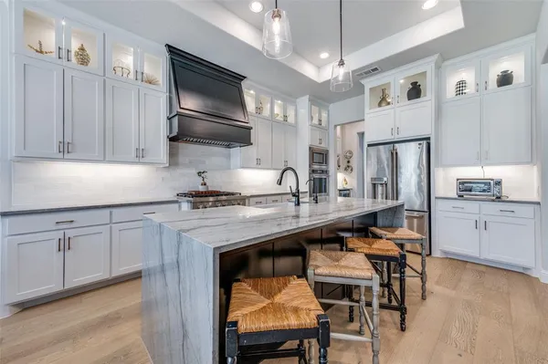 a kitchen with stainless steel appliances granite countertop a table chairs refrigerator and microwave