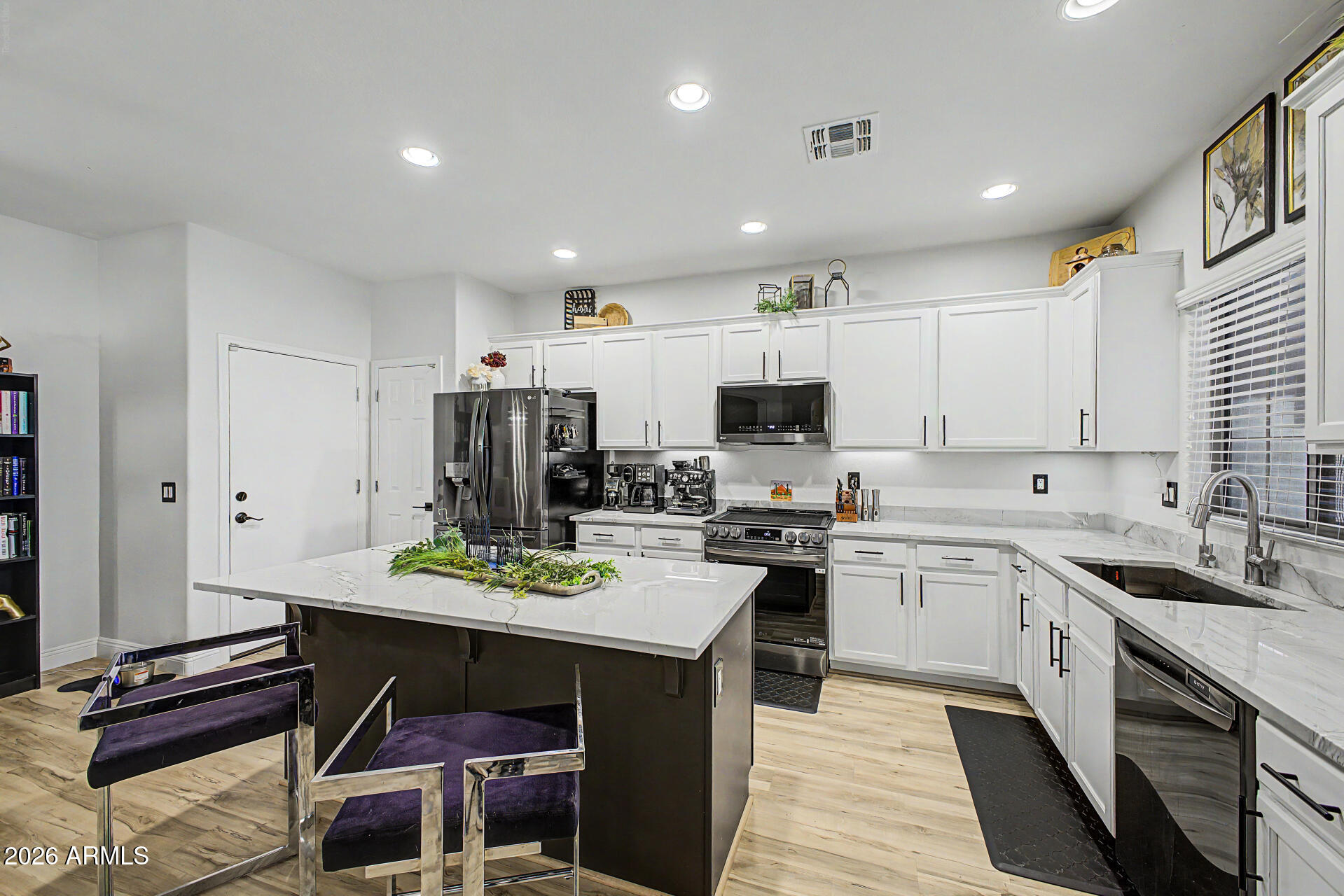 4924 West Harwell Road Laveen, AZ 85339 - Photo 11 of 27 a kitchen with a sink a stove a refrigerator and white cabinets with wooden floor