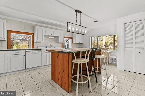 a kitchen with granite countertop cabinets a dining table and a sink