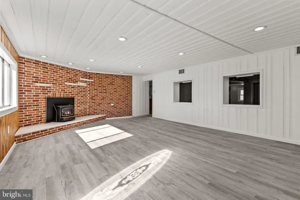 a view of empty room with wooden floor and fireplace