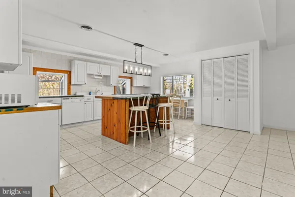 a kitchen with stainless steel appliances a table and chairs in it