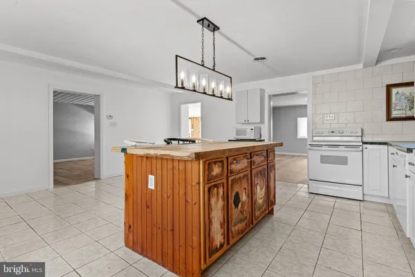 a kitchen with stainless steel appliances granite countertop a sink a stove a refrigerator and island