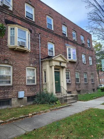 a view of a brick building next to a yard