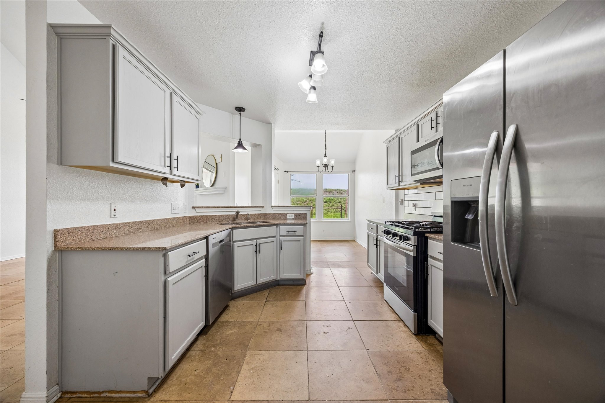 124 Lago Grande Drive Kyle, TX 78640 - Photo 5 of 16 Kitchen with stainless steel appliances, light gray cabinetry, and a subway tile backsplash