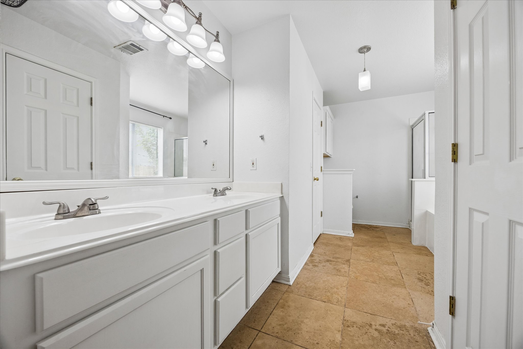 124 Lago Grande Drive Kyle, TX 78640 - Photo 8 of 16 Double vanity with integrated sinks and brushed nickel fixtures, under a large wall-mounted mirror