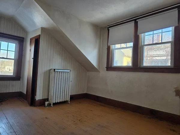 an empty room with a window and a ceiling fan