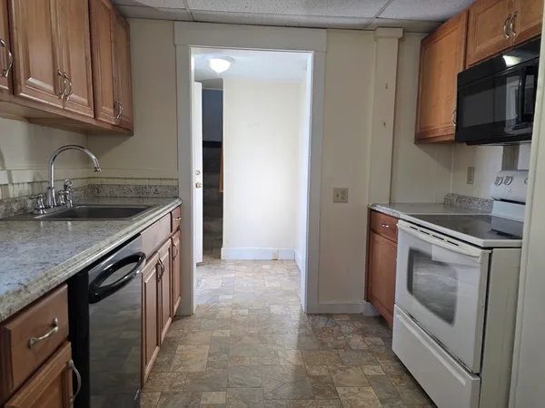a kitchen with stainless steel appliances granite countertop a sink stove and microwave