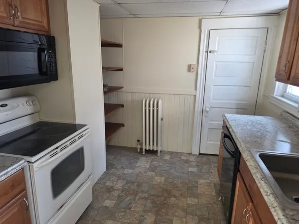 a kitchen with granite countertop a stove and a refrigerator