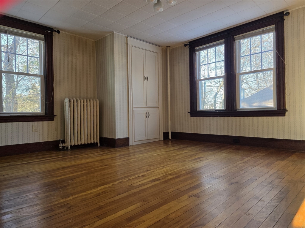 324 1/2 Chestnut Street Clinton, MA 01510 - Photo 8 of 21 an empty room with wooden floor and windows