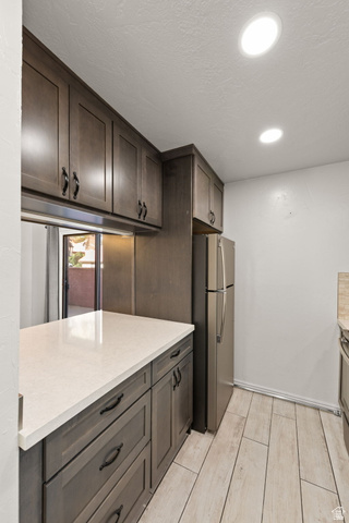 301 South 1200th Street East, Unit 31 St. George, UT 84790 - Photo 15 of 21 Kitchen with wood finish floors, freestanding refrigerator, dark wood finish cabinets, recessed lighting, and a textured ceiling