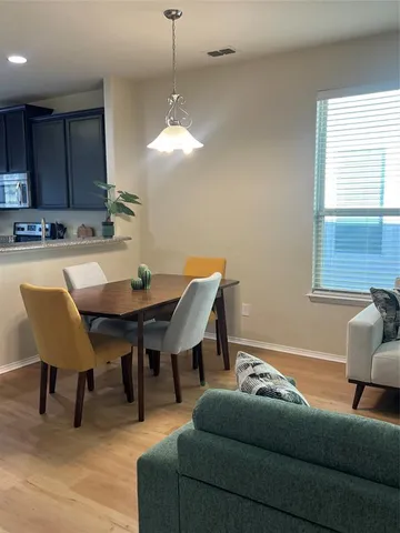 a living room with furniture a wooden floor and a chandelier