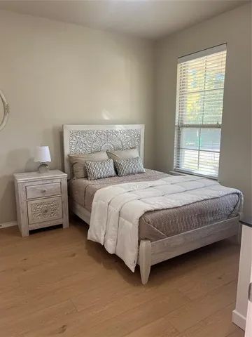 a bedroom with a bed next to a window