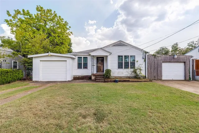 a front view of a house with a garden and yard
