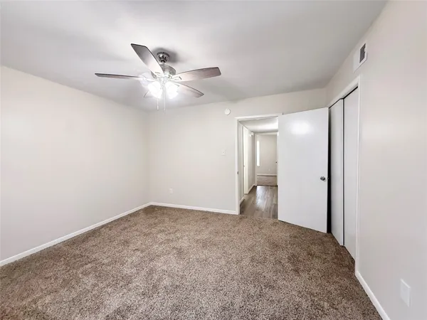 a view of an empty room and a ceiling fan