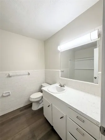 a bathroom with a granite countertop sink mirror and toilet
