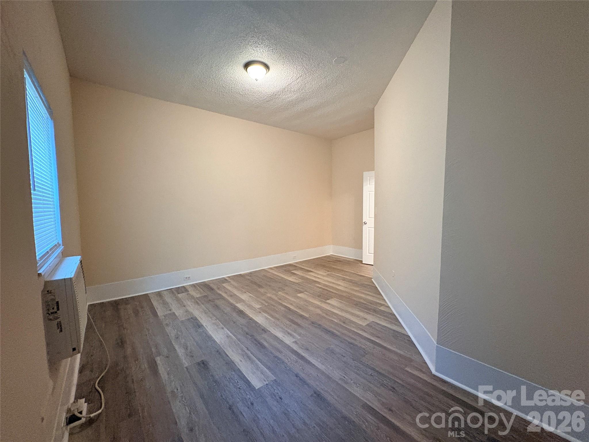 1109 6th Street, Unit B Lancaster, SC 29720 - Photo 19 of 22 an empty room with wooden floor and windows