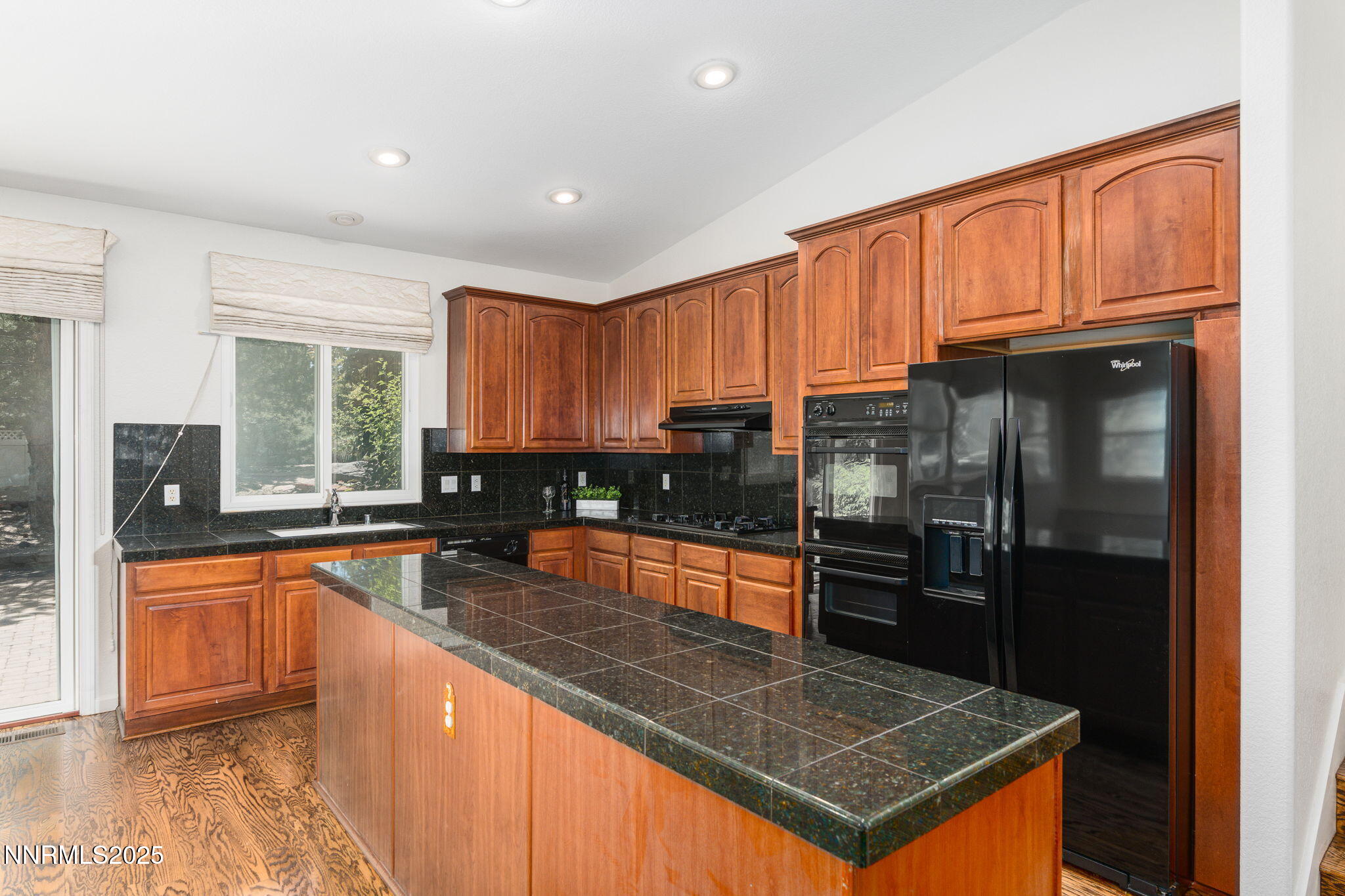 1300 Flanders Road Reno, NV 89511 - Photo 5 of 46 a kitchen with stainless steel appliances granite countertop a refrigerator a stove top oven and granite countertops with wooden floor