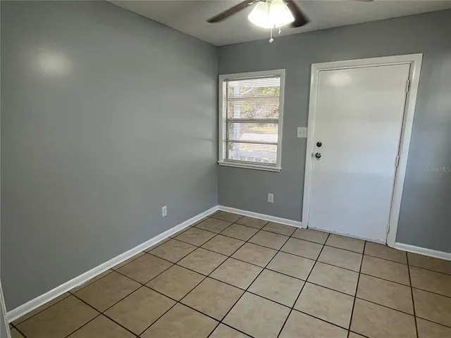 an empty room with windows and fan
