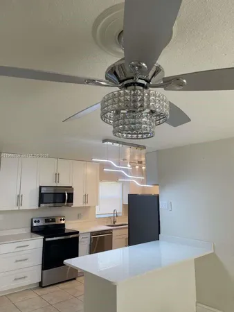 a kitchen with kitchen island stainless steel appliances a counter space and cabinets