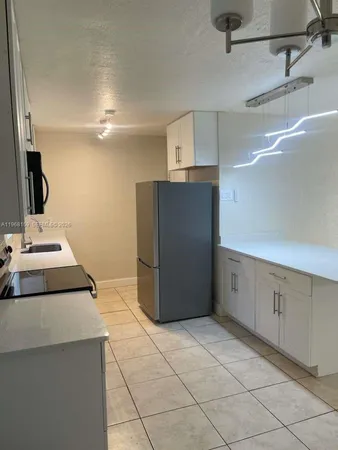 a view of a kitchen with furniture and wooden floor