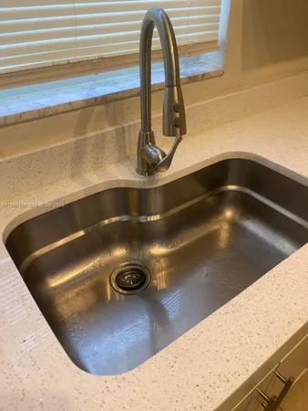 a view of a kitchen with a sink and refrigerator
