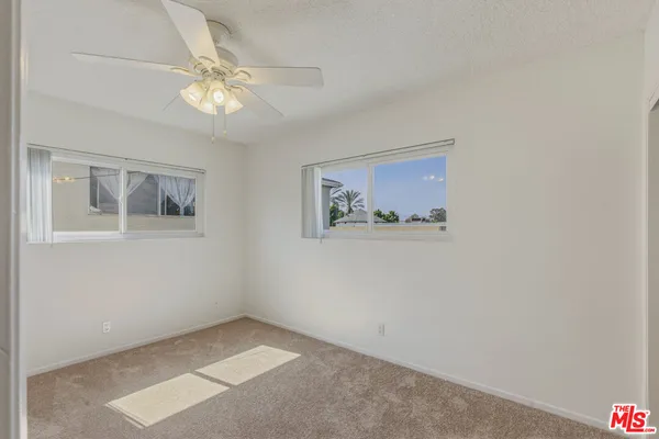 an empty room with a ceiling fan and a window