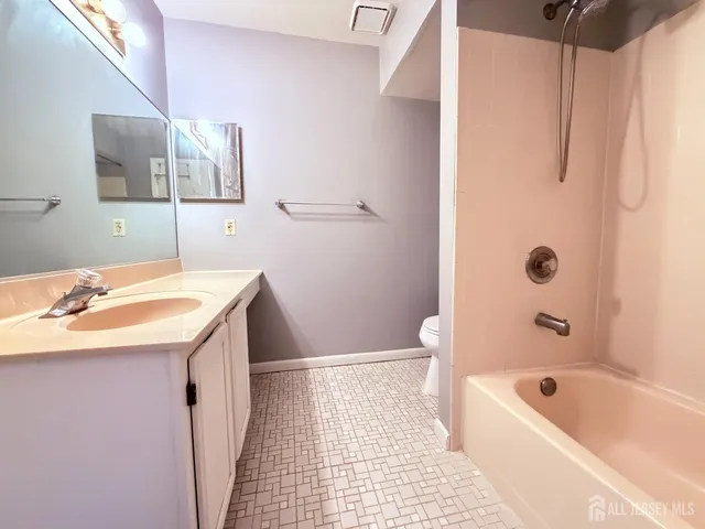 a bathroom with a sink a toilet a shower curtain and a bath tub