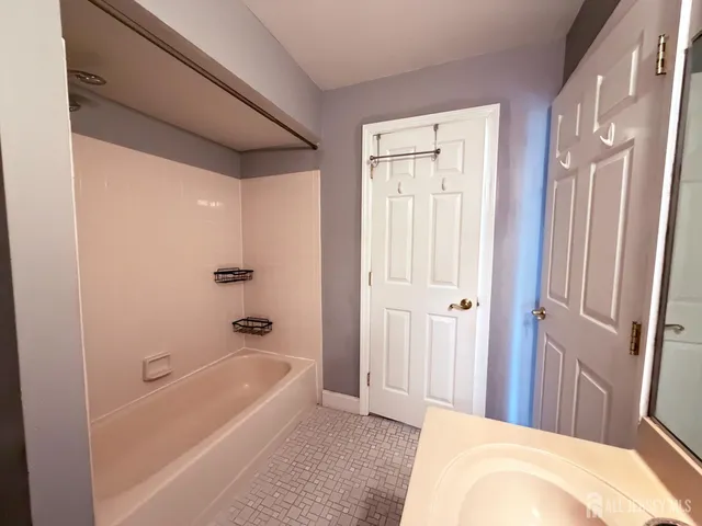 a bathroom with a tub shower and sink