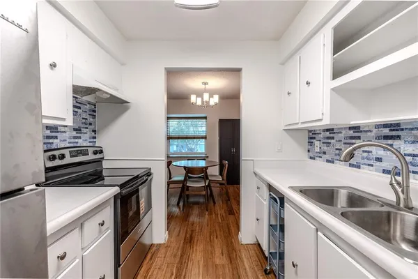 a kitchen with a stove a sink and a refrigerator