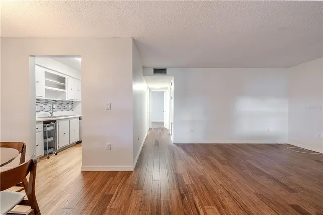 a view of a livingroom with wooden floor and furniture