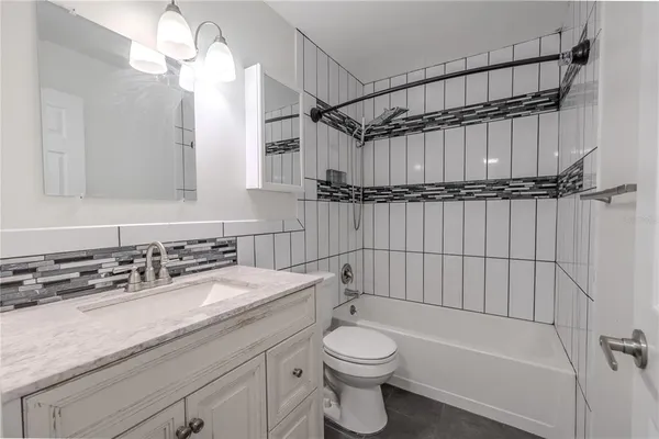 a bathroom with a sink a toilet a mirror and shower