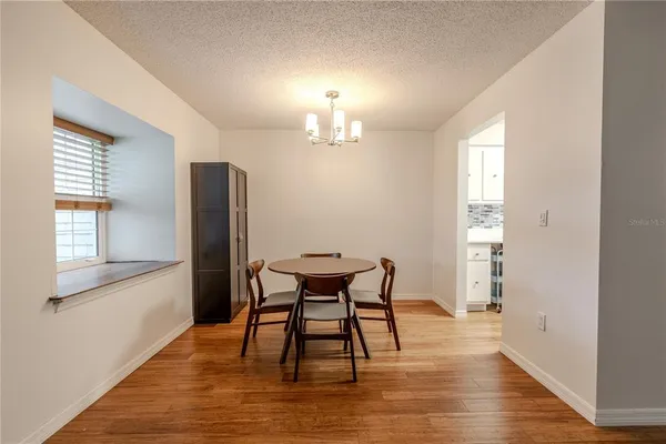 a view of a dining room with furniture a chandelier and wooden floor